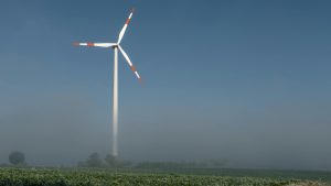 A wind turbine stands tall amidst a foggy winter landscape in Höxter, Germany.