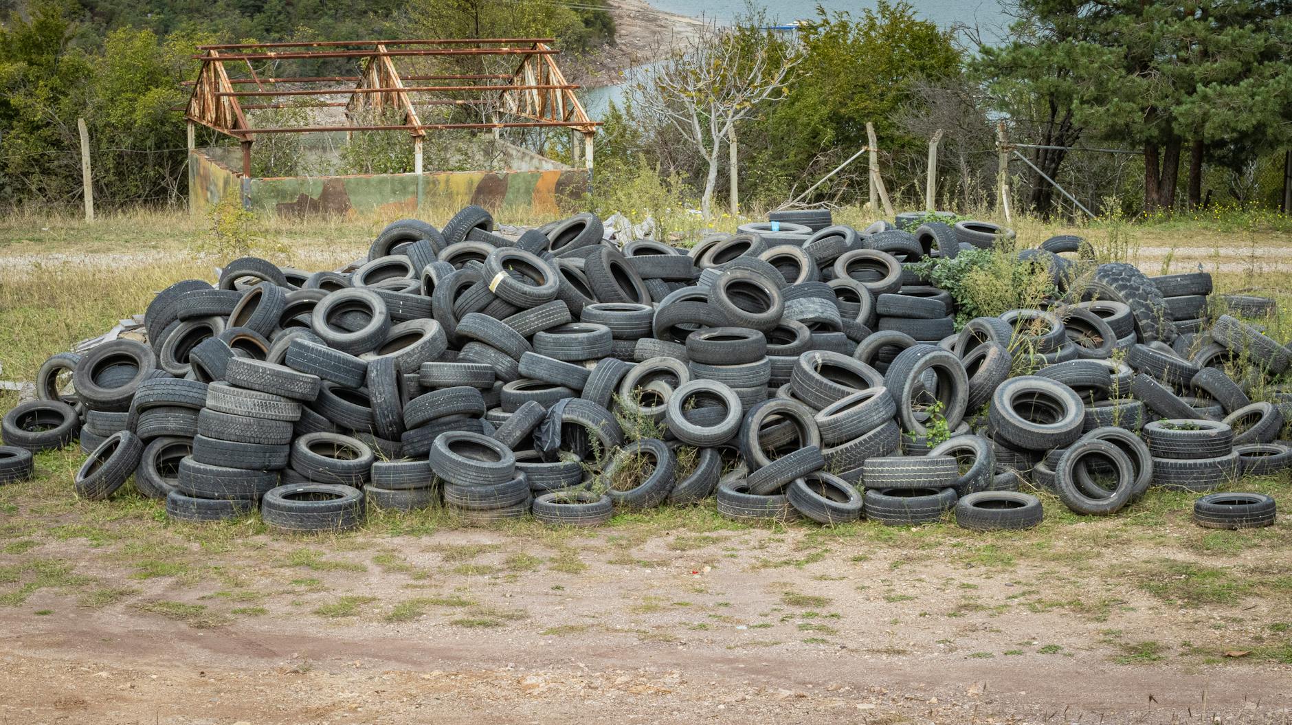 A pile of discarded tires in an outdoor setting surrounded by greenery in Artvin, Türkiye.