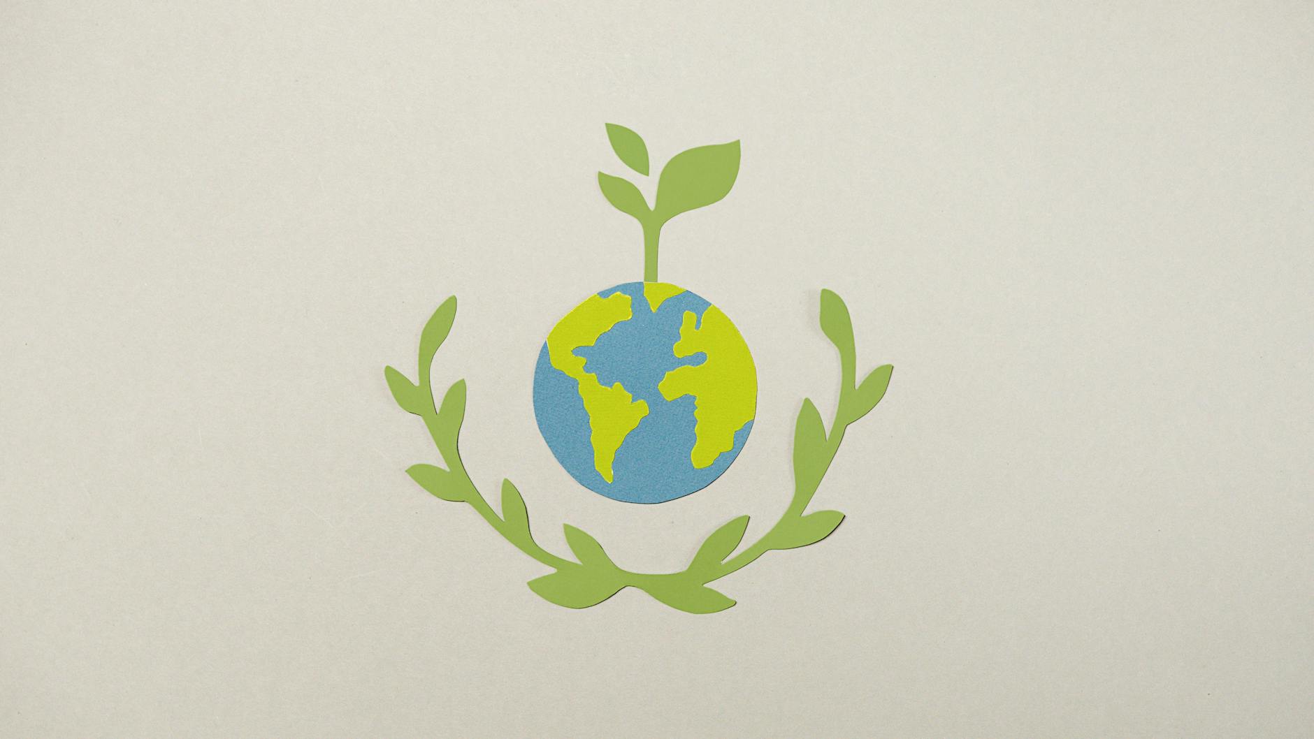 Paper cutout of Earth with plant symbolizing environmental conservation.