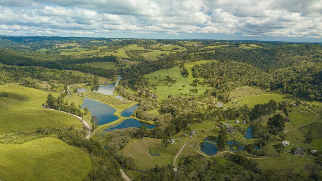 Breathtaking aerial photograph showcasing a lush green countryside with lakes and forests.