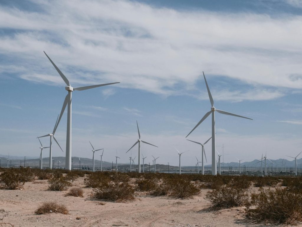 A scenic view of wind turbines in a desert, symbolizing clean, renewable energy technology.