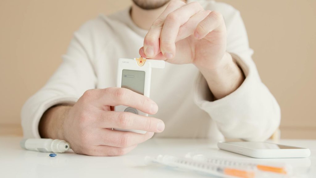 Close-up of a person checking blood sugar with a glucose meter at home.